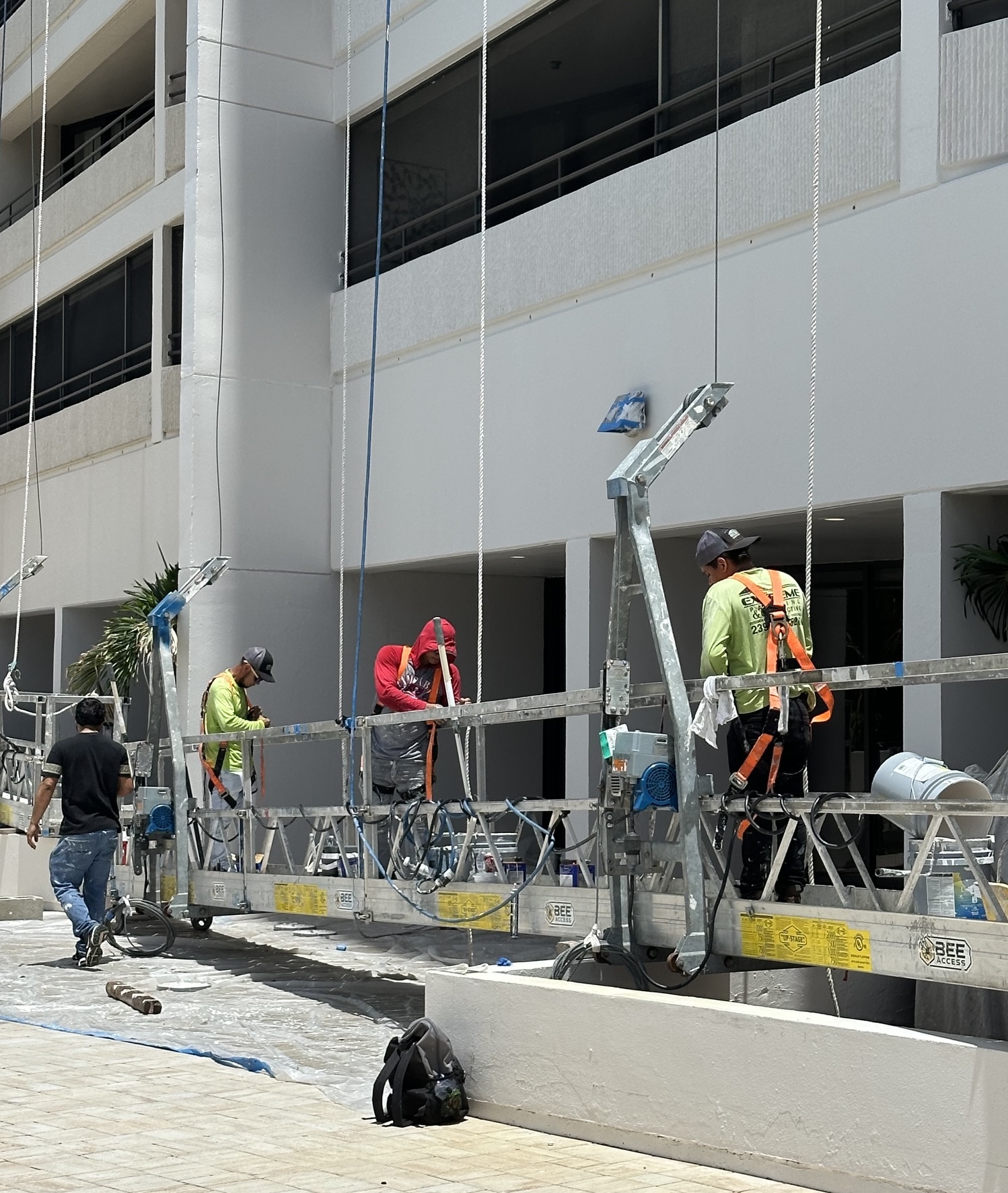 Painters on scaffolding repainting the exterior of the Ariel high-rise