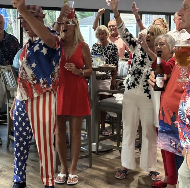Guests in red, white and blue raising a toast at Wheelhouse Grille