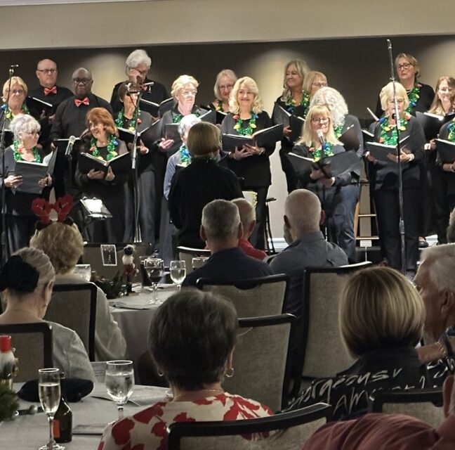 Landings Chorus performing before a seated audience at the Helm Club